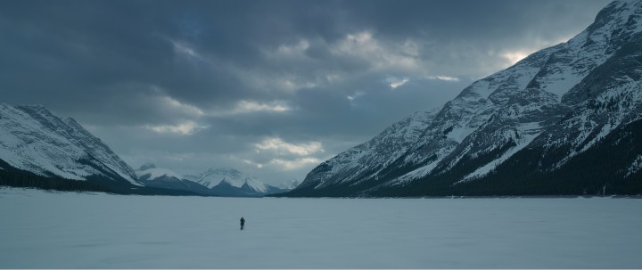 Screenshot from the film "The Revenant" shows tiny figure on a vast, snowy plain