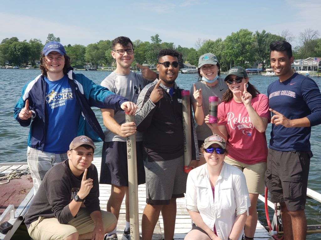 students on a dock with a collected core with dr. jackie