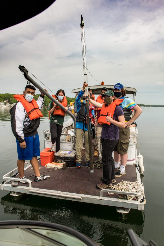 students posing on boat with core collected